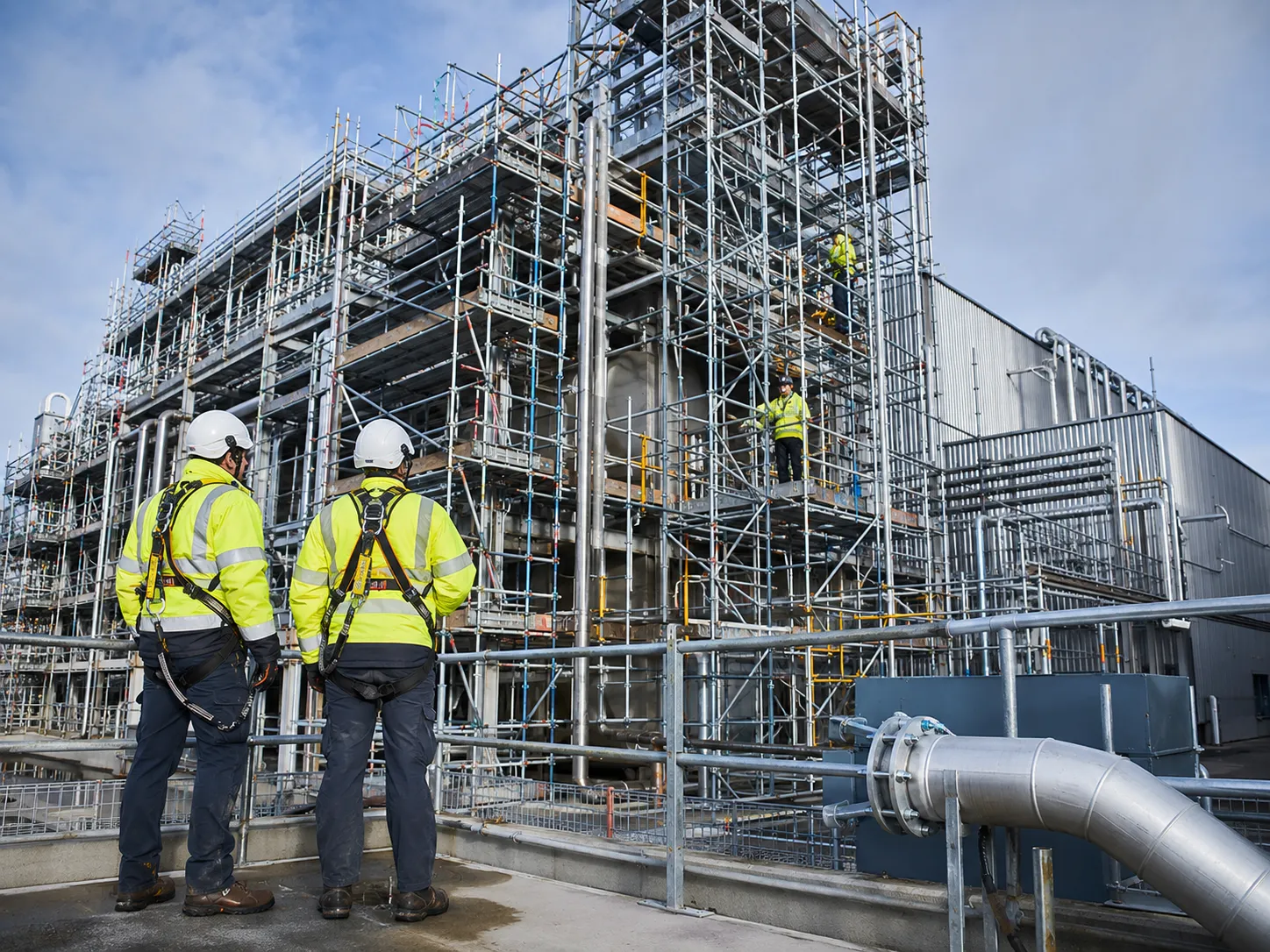 Close-up of certified scaffolders actively constructing safe access.