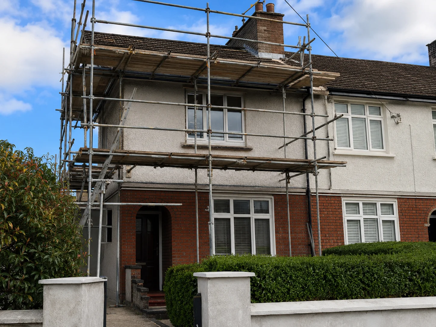 Traditional tube-and-fitting scaffolding erected safely on a residential semi-detached house facade in Glasnevin, Dublin for a domestic roof repair project.
