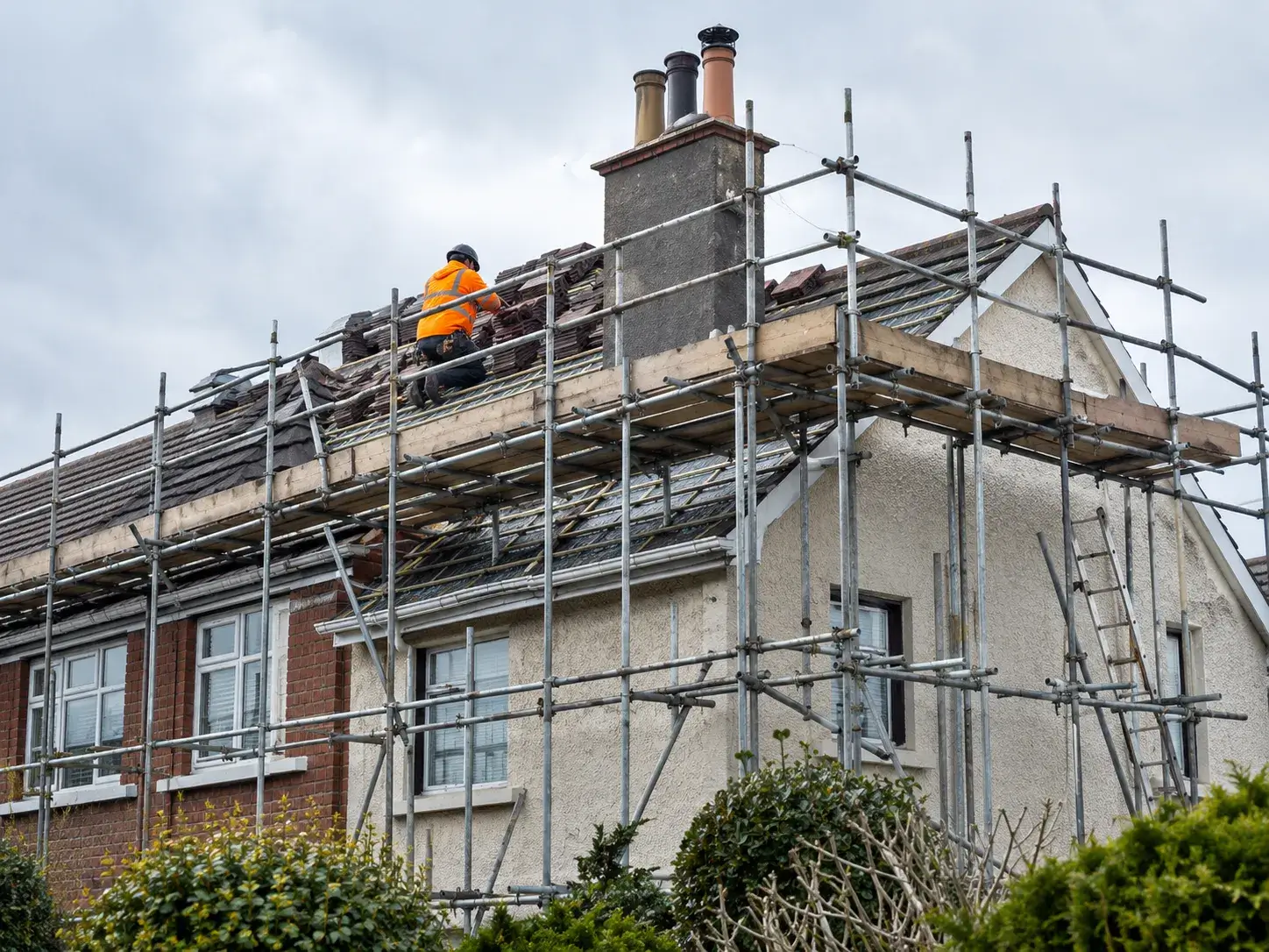 Secure residential scaffolding built around a roof edge and chimney stack for a home re-roofing and chimney repair renovation in Ireland.