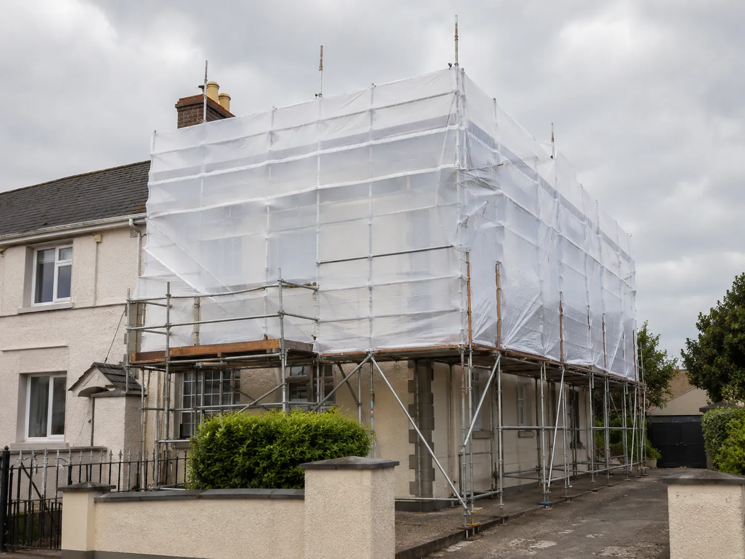 A single-use shrink-wrap cladding alternative applied directly over an existing scaffold frame structure.